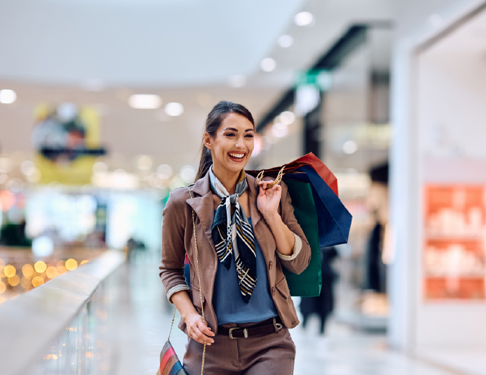 Woman carrying shopping bags in a mall near Meadows Apartments - Universal City, TX